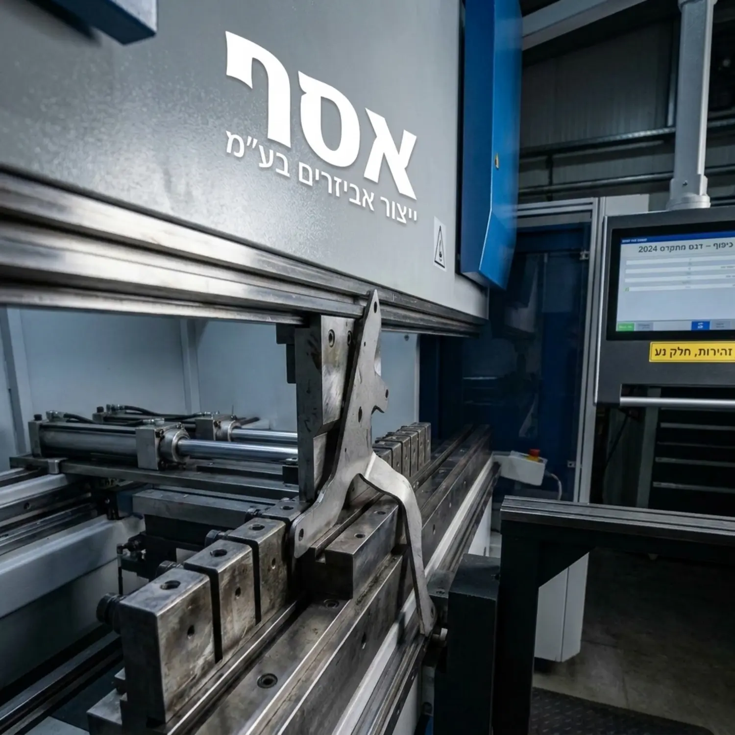 צילום תקריב של אצבעות העוצר האחורי במכונת CNC מתקדמת כשהן תומכות בחלק מתכת א סימטרי מורכב רגע לפני פעולת הכיפוף